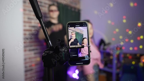 A guy and a girl dance on a smartphone camera. A view of the phone screen standing on a tripod. Social network. Blogger