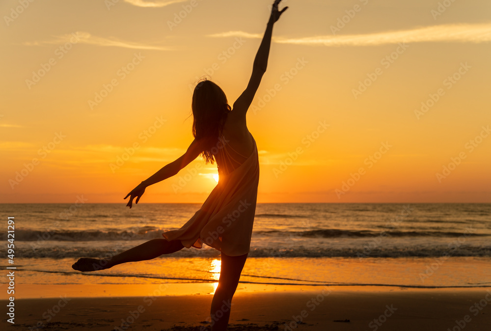 Sunset view carefree young girl dancing on beach