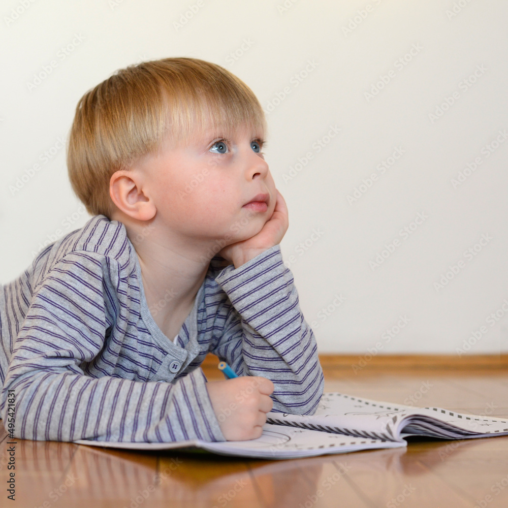 cute boy reads the book on the floor at home cute boy reads the book on the floor at home