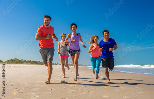 Happy friends enjoying healthy exercise jogging on beach