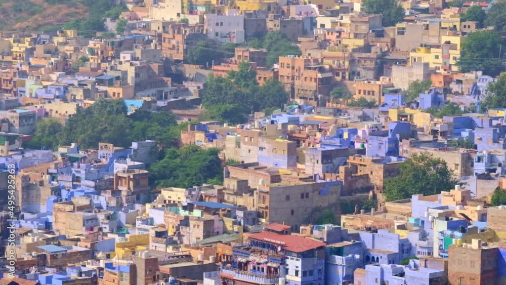 Jodhpur the Blue City aerial view. Blue painted houses and birds flying in the morning above brahmin houses, view from Mehrangarh Fort, Rajasthan, India. Camera zoom out Jodhpur the Blue City aerial view. Blue painted houses and birds flying in the morning above brahmin houses, view from Mehrangarh Fort, Rajasthan, India. Camera zoom out