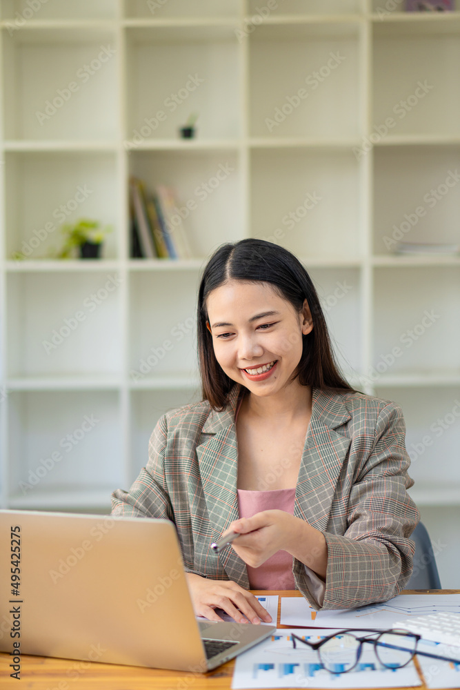 A business analyst or accountant calculates and examines financial documents. Asian businesswoman making calculations Concept of saving, finance and economy via laptop. A business analyst or accountant calculates and examines financial documents. Asian businesswoman making calculations Concept of saving, finance and economy via laptop.