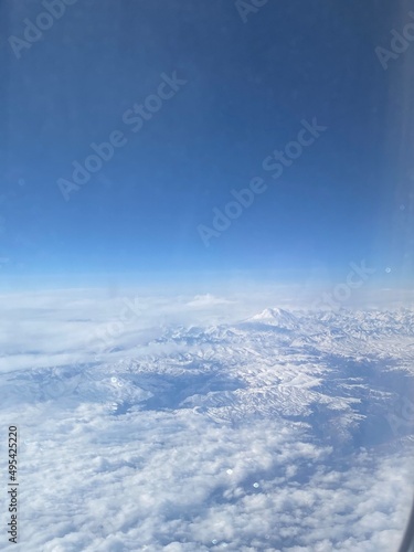 Aerial view of snow capped mountains. airplane wing above earth. Photos from the windows of the plane that are going to Airport.