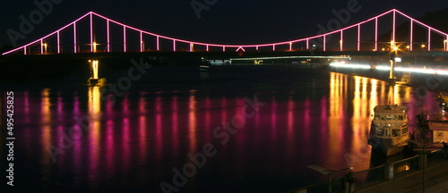 Park pedestrian bridge over the Dnieper River in the capital of Ukraine - Kyiv at night with beautiful backlight