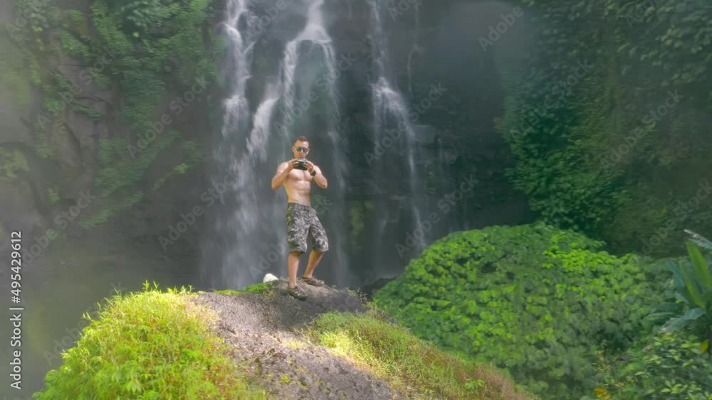 Travel people enjoy beautiful waterfall hidden in tropical rainforest jungle on nature background 4K Aerial view Travel people enjoy beautiful waterfall hidden in tropical rainforest jungle on nature background 4K Aerial view