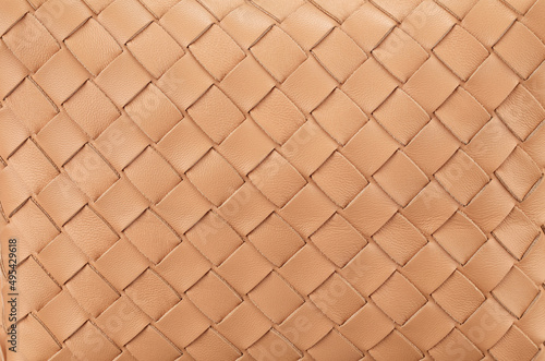 Texture of braided genuine leather of excellent workmanship in a rich beige color. A great background for the banner. Horizontal arrangement.