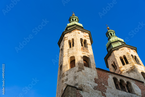 Two gothic towers in old Krakow at sunset in the rays of the evening sun against the blue sky © Александр Бочкала