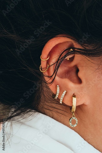 Close up of the woman with multiple piercings on the ear