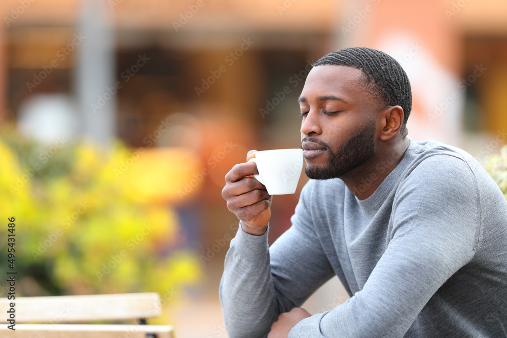 Man with black skin relaxing drinking coffee in a bar Man with black skin relaxing drinking coffee in a bar