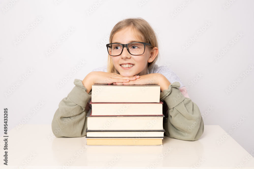 Beautiful smiling positive cheerful girl in glasses with pile of books isolated on white background. Beautiful smiling positive cheerful girl in glasses with pile of books isolated on white background.