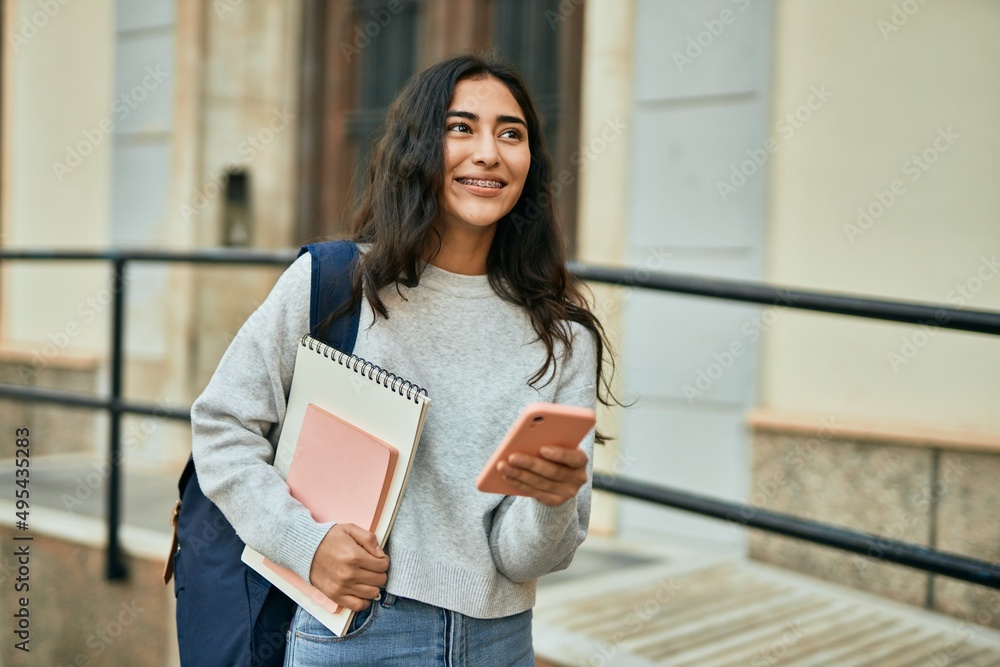 Young middle east student girl smiling happy using smartphone at the city. Young middle east student girl smiling happy using smartphone at the city.