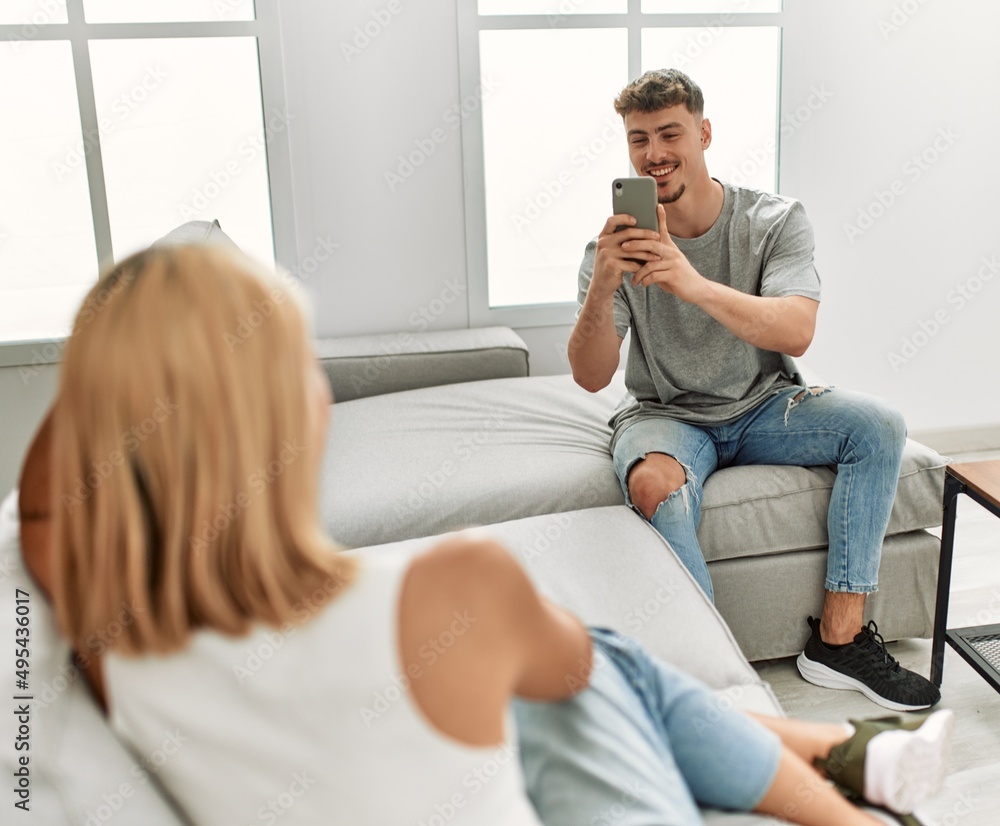 Obraz premium Man making photo to his girlfriend using smartphone at home.