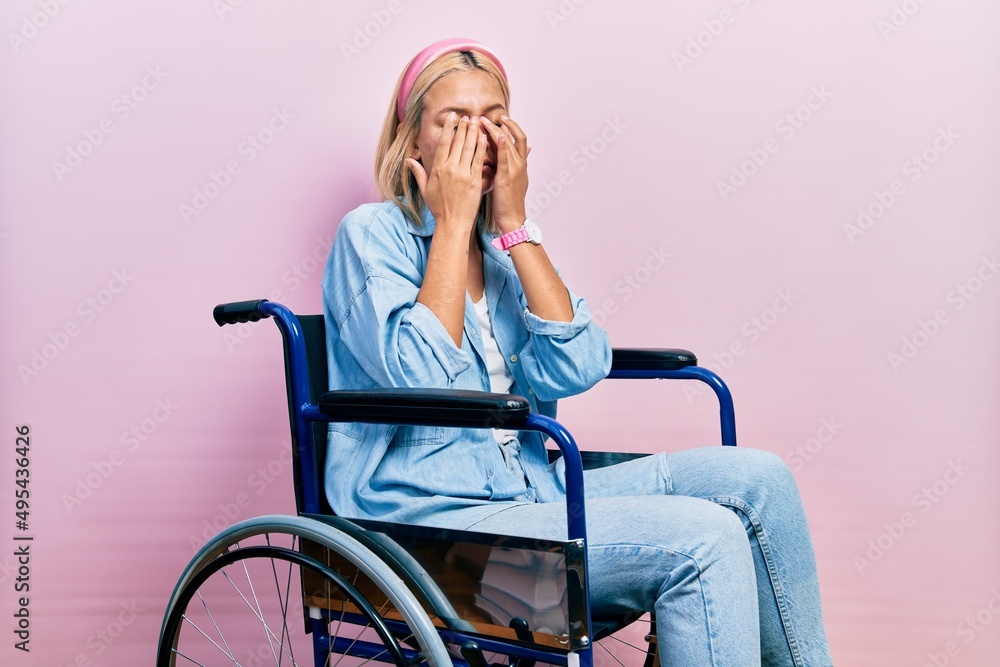 Beautiful blonde woman sitting on wheelchair rubbing eyes for fatigue and headache, sleepy and tired expression. vision problem Beautiful blonde woman sitting on wheelchair rubbing eyes for fatigue and headache, sleepy and tired expression. vision problem