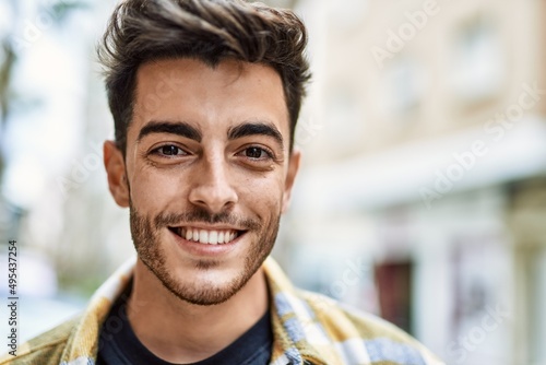 Handsome hispanic man smiling happy and confident at the city