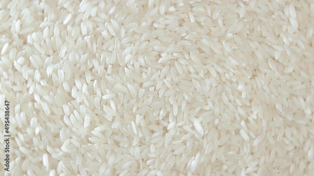 Dry Uncooked White Rice Background Rotating Right - Top View. Scattered Raw Long Grain Rice. Asian Cuisine and Culture. Healthy Eating Ingredients. Diet Food Dry Uncooked White Rice Background Rotating Right - Top View. Scattered Raw Long Grain Rice. Asian Cuisine and Culture. Healthy Eating Ingredients. Diet Food