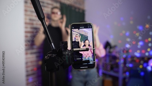 A guy and a girl dance on a smartphone camera. A view of the phone screen standing on a tripod. Social network. Blogger