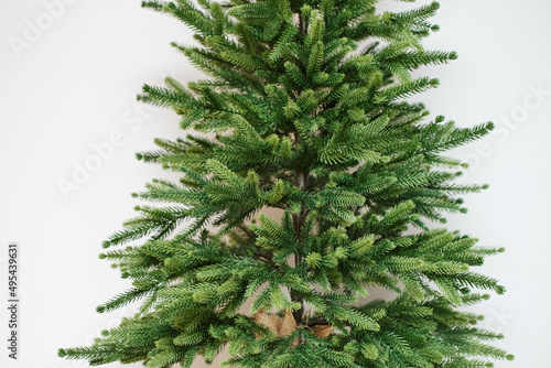Decorative artificial coniferous tree on a white background