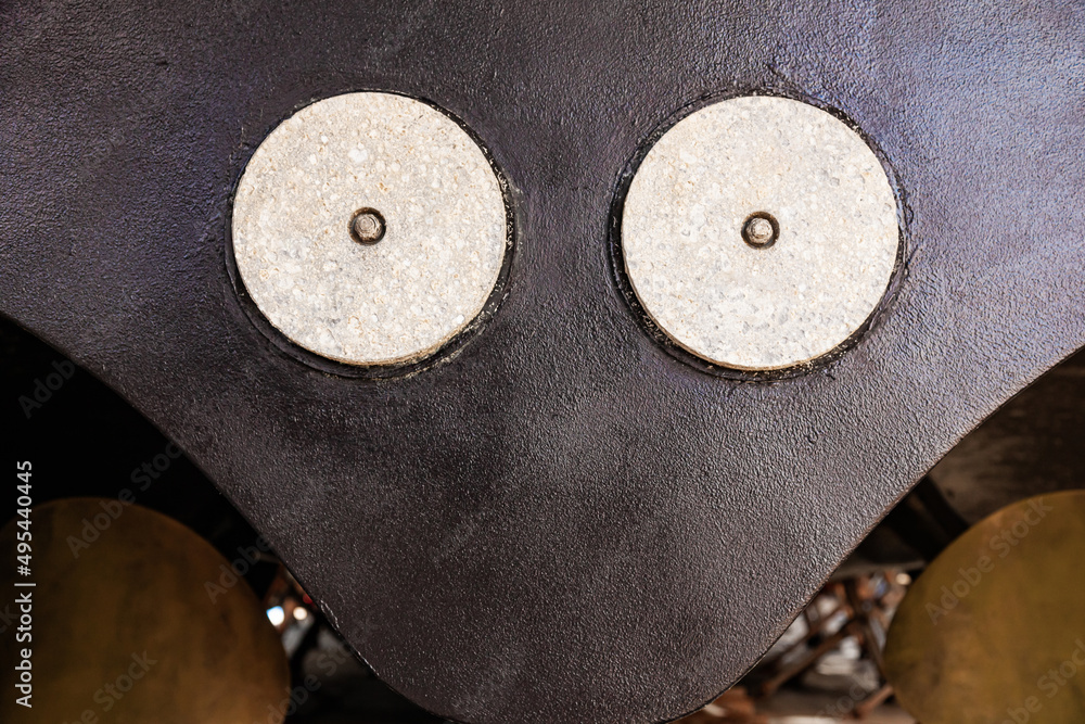 The back of a large motor yacht, standing on wooden blocks in a dry