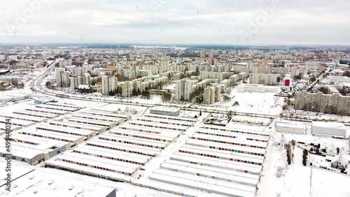 Colorful garage box doors and living district of Kaunas city during snowfall, aerial ascend view photo