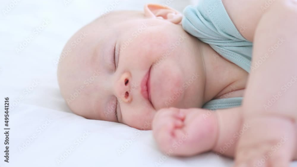 close-up portrait of sleeping infant of three months baby, child lying with closed eyes, opened mouth on white bed. little baby kid moving in dream, while sleeping to napping. asleep child in bedroom close-up portrait of sleeping infant of three months baby, child lying with closed eyes, opened mouth on white bed. little baby kid moving in dream, while sleeping to napping. asleep child in bedroom