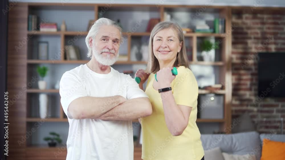 portrait of an old senior active sporty fitness gray-haired retired couple looking at camera. Happy Mature Cheerful family Smile standing during joint workout at home. Healthy lifestyle in retirement portrait of an old senior active sporty fitness gray-haired retired couple looking at camera. Happy Mature Cheerful family Smile standing during joint workout at home. Healthy lifestyle in retirement