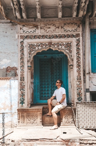 Man sitting beside Indian style window photo