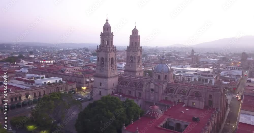 Drone flies over Morelia, Mexico at sunrise. Drone panning left around the cathedral with the waking city being revealed behind. Drone flies over Morelia, Mexico at sunrise. Drone panning left around the cathedral with the waking city being revealed behind.