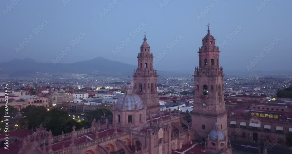 Drone flies over Morelia, Mexico at sunrise. Drone flying backwards away from the cathedral revealing the city and mountains behind. Drone flies over Morelia, Mexico at sunrise. Drone flying backwards away from the cathedral revealing the city and mountains behind.
