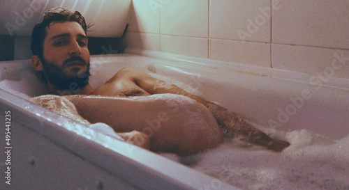 Naked man in foamy bathtub