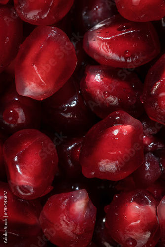 Pomegranate seeds close-up. Red on black. Macrophotography. Healthy food and vitamins.