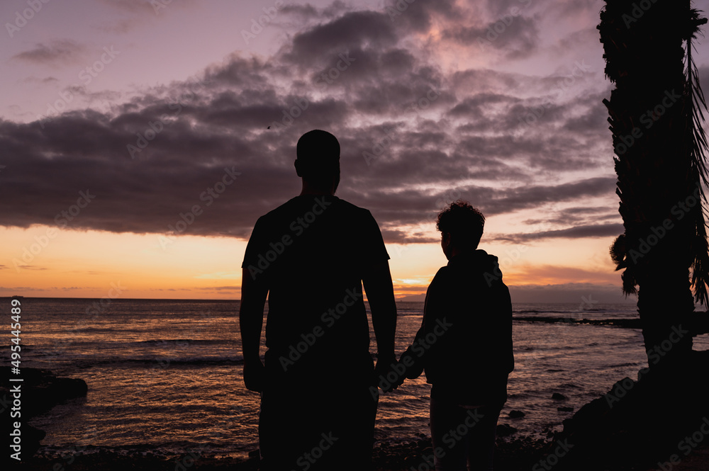 Horizontal banner or header Silhouette couple standing against a beautiful dramatic sky at the sea during sunset with a palm tree.