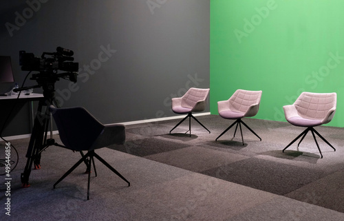 Three chairs against green backdrop at a studio