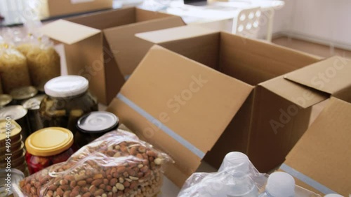 charity, humanitarian aid and donation concept - close up of packed food, drinks and boxes at distribution or refugee assistance center