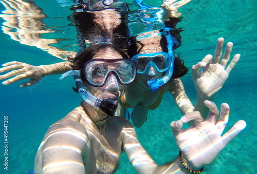 Underwater selfie of young couple snorkeling in swimming pool photo
