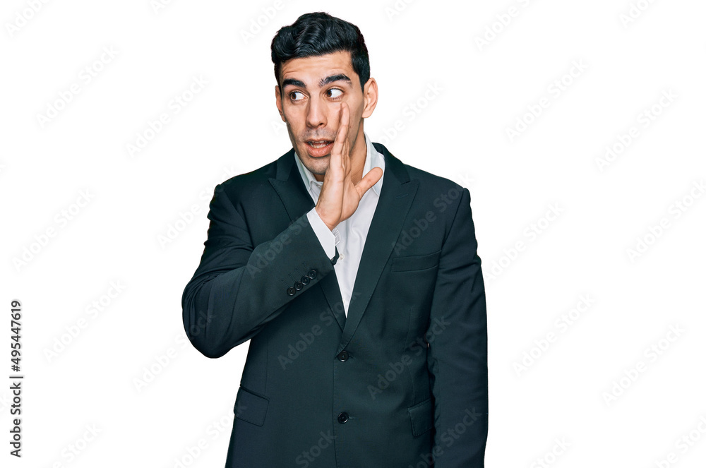 Handsome hispanic man wearing business clothes hand on mouth telling secret rumor, whispering malicious talk conversation Handsome hispanic man wearing business clothes hand on mouth telling secret rumor, whispering malicious talk conversation