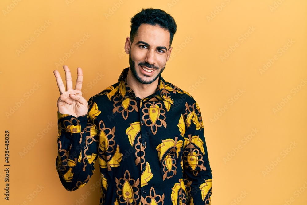 Young hispanic man wearing casual shirt showing and pointing up with fingers number three while smiling confident and happy. Young hispanic man wearing casual shirt showing and pointing up with fingers number three while smiling confident and happy.