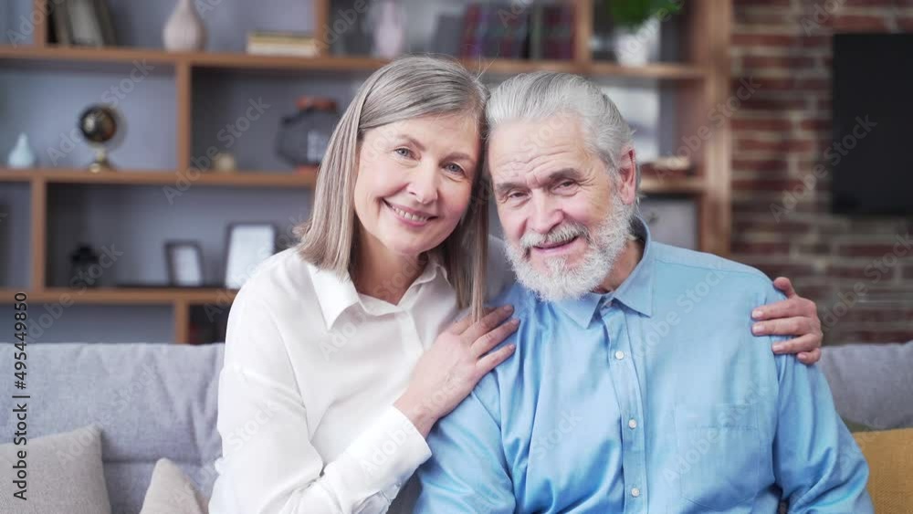 portrait of close up happy senior gray haired, married couple looking at camera while standing in room at home. Indoor. Husband and wife retirees smiling. Old people hug. Joyful grandparents bonding portrait of close up happy senior gray haired, married couple looking at camera while standing in room at home. Indoor. Husband and wife retirees smiling. Old people hug. Joyful grandparents bonding