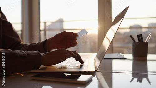 Man making online payment with credit card and laptop computer. Business, online shopping, e-commerce, internet banking, spending money, working from home concept photo