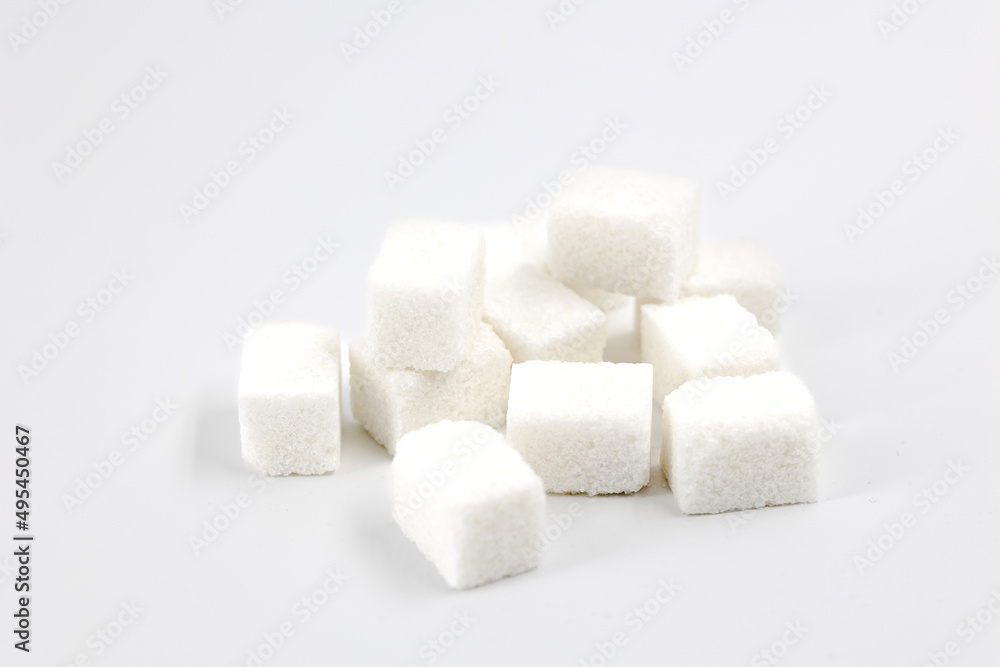 Heap of sugar cubes on white background close-up top view