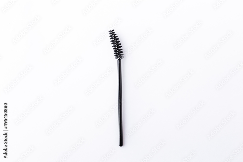 one short small black eyelash brush isolated on white background close-up top view one short small black eyelash brush isolated on white background close-up top view