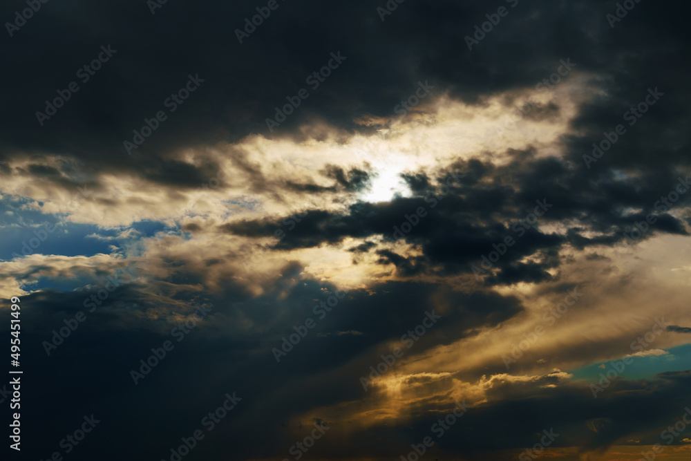 beautiful dramatic sky, bright sunlight and dark silhouette of clouds as background