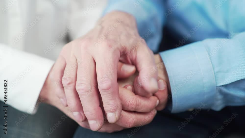 close up older elderly people hands. Old man holds a woman hand sitting together at home indoor. Senior couple mature family husband and wife grandparents together support trust in marriage. Closeup close up older elderly people hands. Old man holds a woman hand sitting together at home indoor. Senior couple mature family husband and wife grandparents together support trust in marriage. Closeup