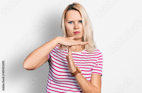 Young caucasian woman wearing casual clothes doing time out gesture with hands, frustrated and serious face