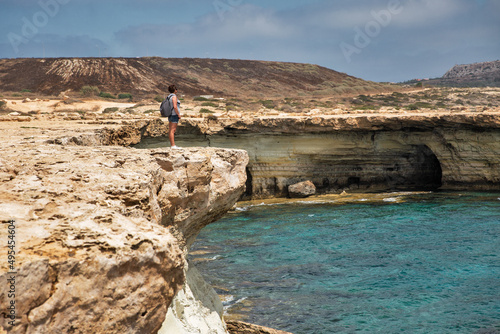 Woman standing over a cliff. Cape Greco peninsula park, Cyprus. © Panama