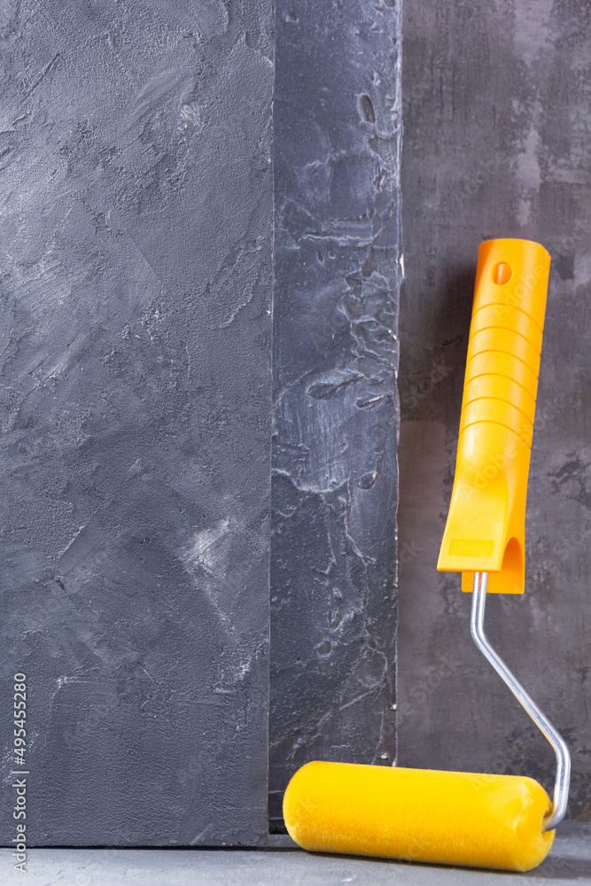 Paint roller construction tool on cement wall background