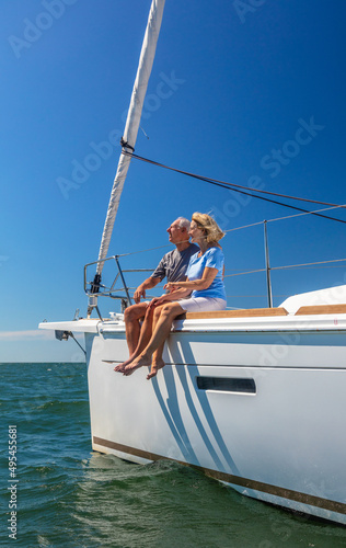 Happy retired couple on vacation relaxing on yacht
