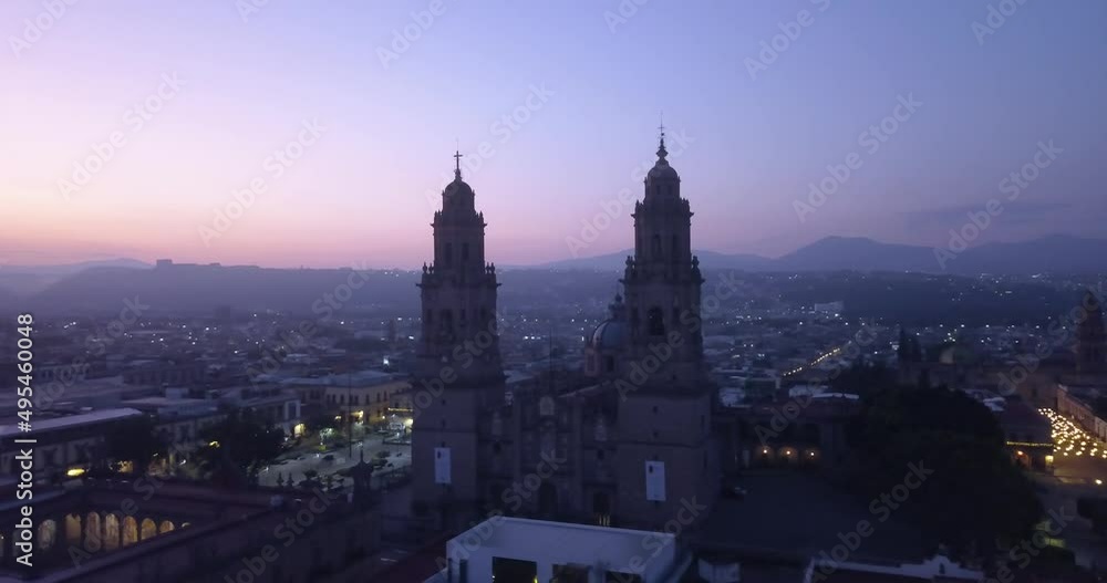 Drone flies over Morelia, Mexico at sunrise. Drone panning right around the cathedral revealing the city and mountains behind. Drone flies over Morelia, Mexico at sunrise. Drone panning right around the cathedral revealing the city and mountains behind.