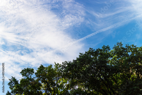 Autumnal clouds and vapor trail float over the trees in East Village on October 08  2021 in New York City NY USA.