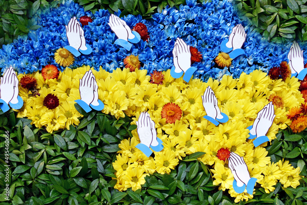 Abstract view with map of Ukraine in blue and yellow flowers in col.rs of the national flag and hands in prayer. (War in Ukraine, prayer for peace - concept)/