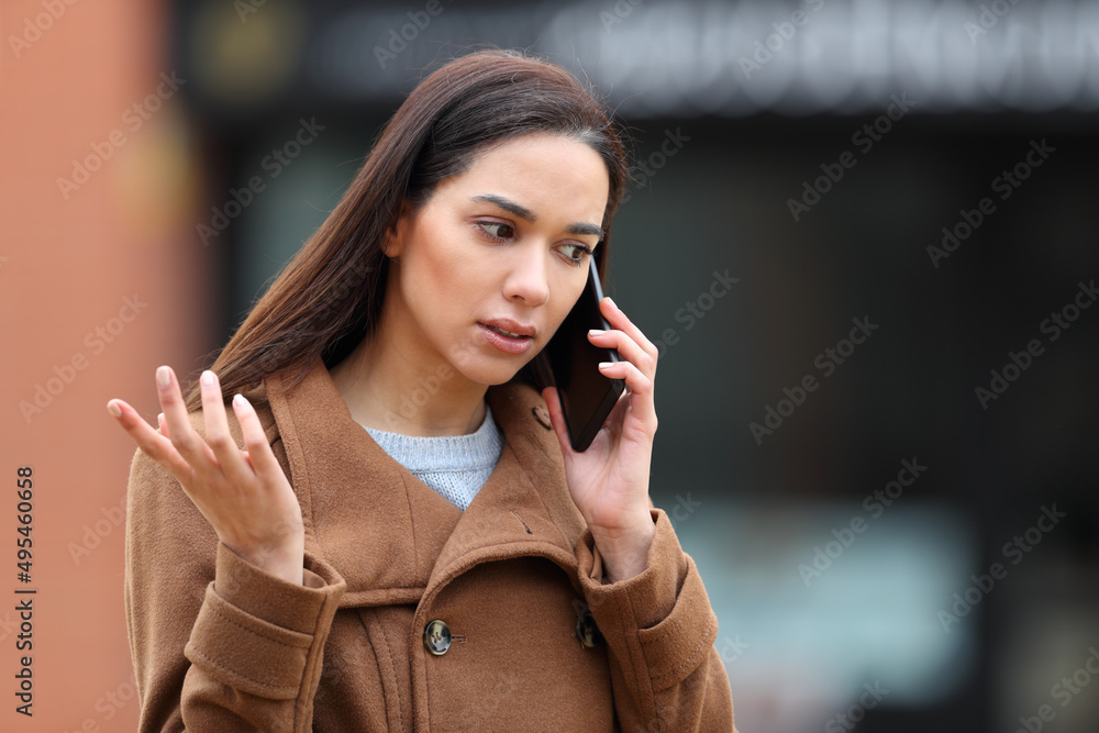 Angry woman in the street talking on phone - obrazy, fototapety, plakaty 